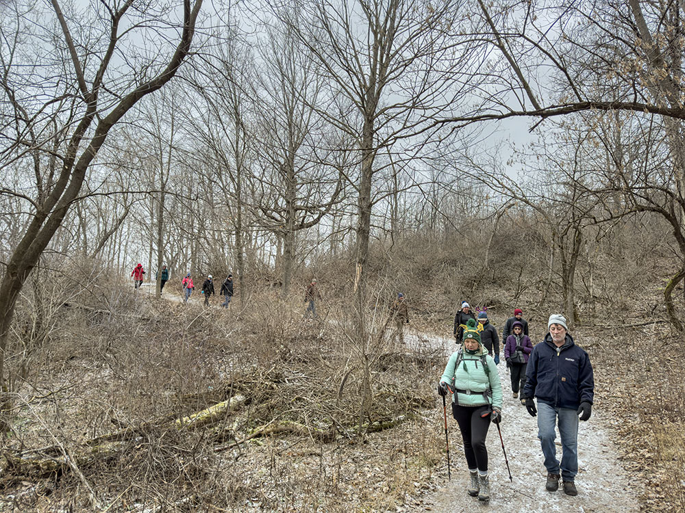 A group of hikers strung out along the icy Ice Age Trail.