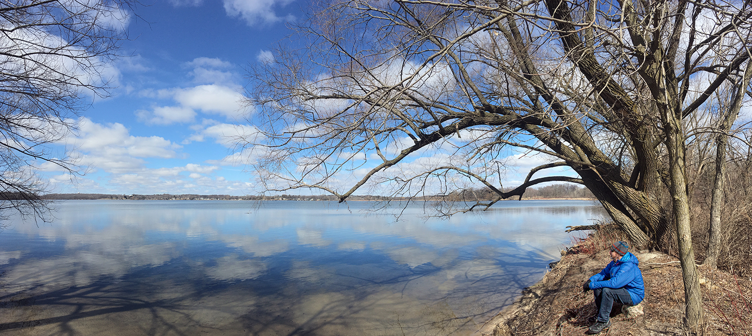 a man sitting on the shore overlooking Pike Lake