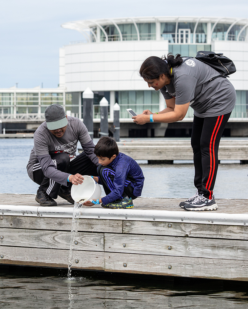 family on dock releasing sturgeon