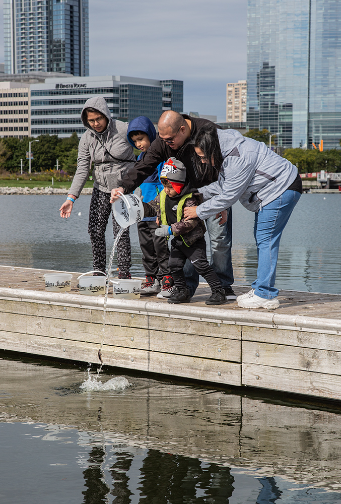 family on dock releasing sturgeon