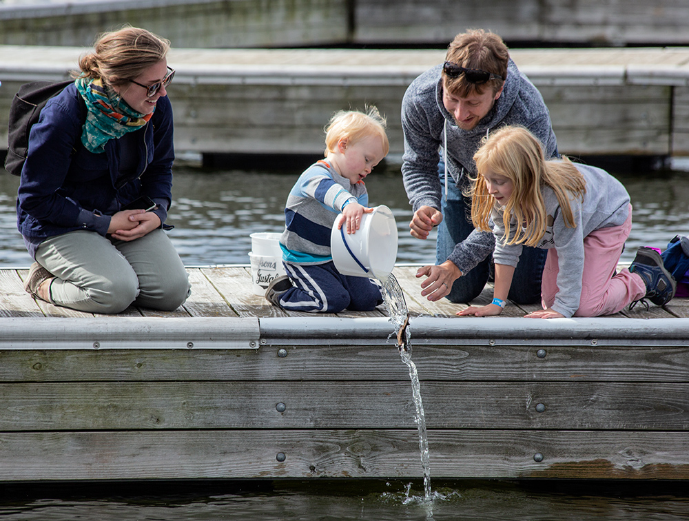 Family on dock releasing sturgeon