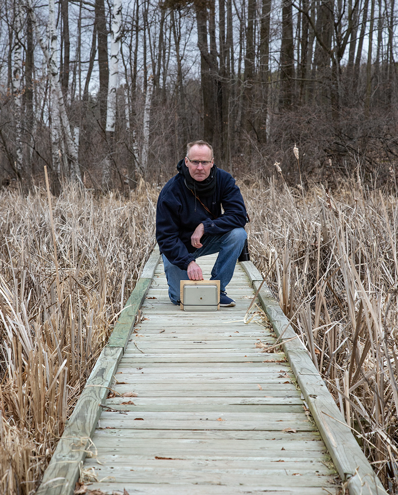 The artist on boardwalk with pinhole camera