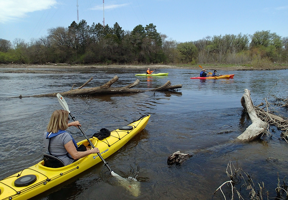 three kayaks heading upstream