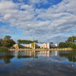 the Washington Park branch of the Urban Ecology Center with clouds reflecting in the lagoon