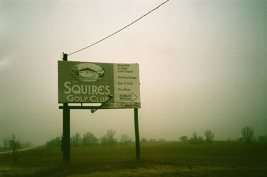 Billboard reading "Squires Golf Club" in fog