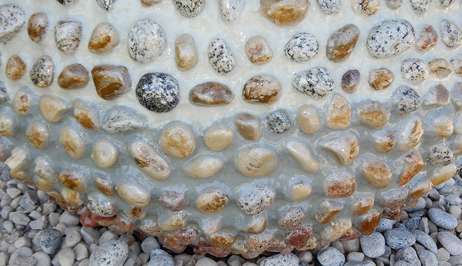 Close up detail of sculpture made of Lake Michigan rock, glow-in-the-dark pebbles, glitter grout and resin