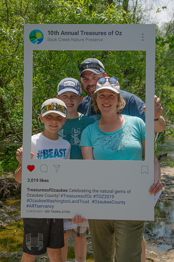 family of four in Instagram frame posing for a selfie at the creek