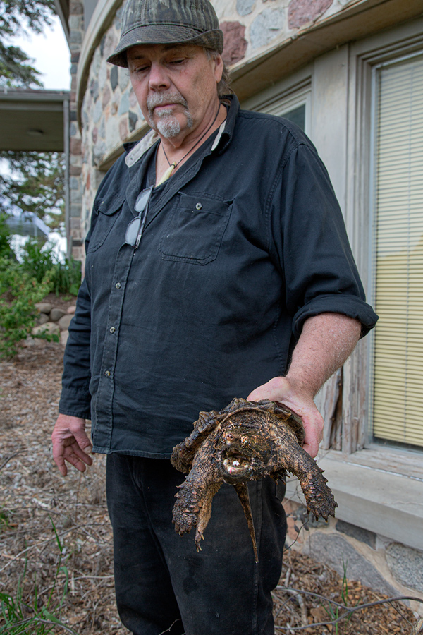 man holding snapping turtle