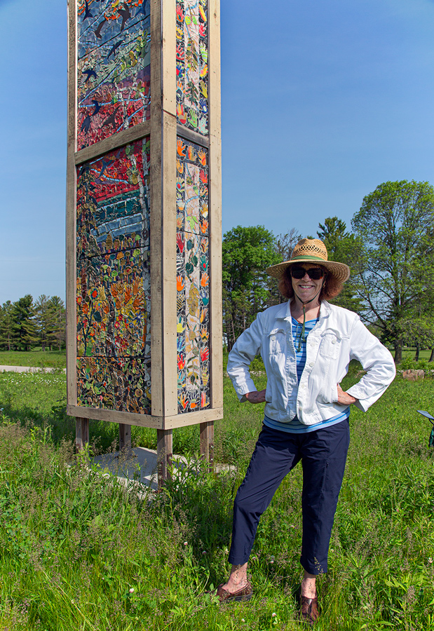 Artist Sally Duback with her colorful art installation, which functions as a chimney swift tower