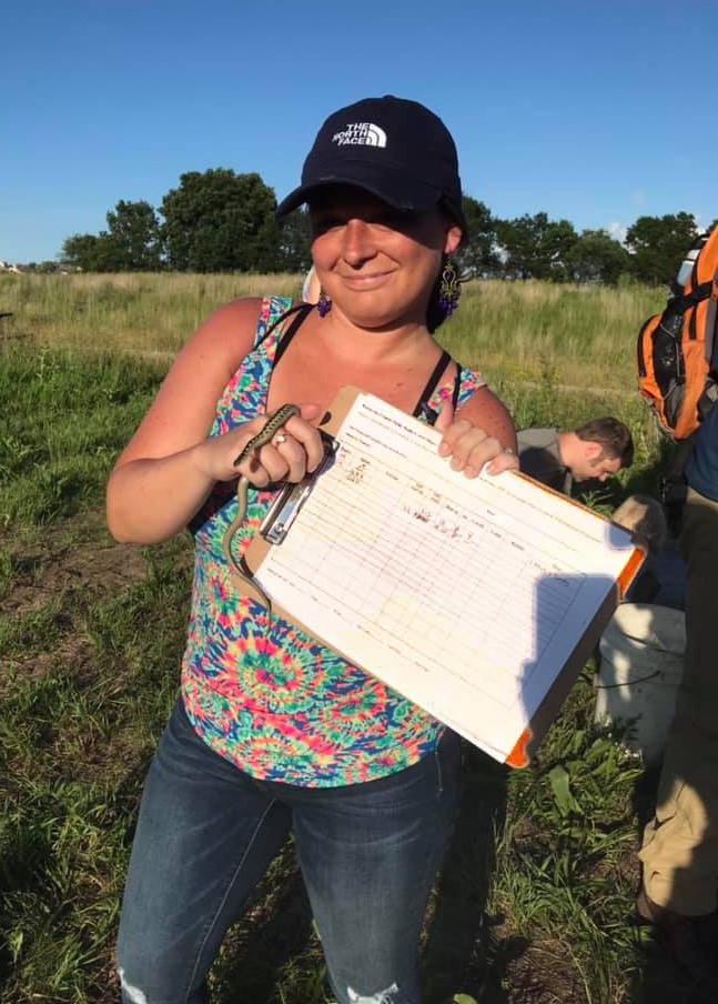 Volunteer Heather holds a common garter snake and data sheet