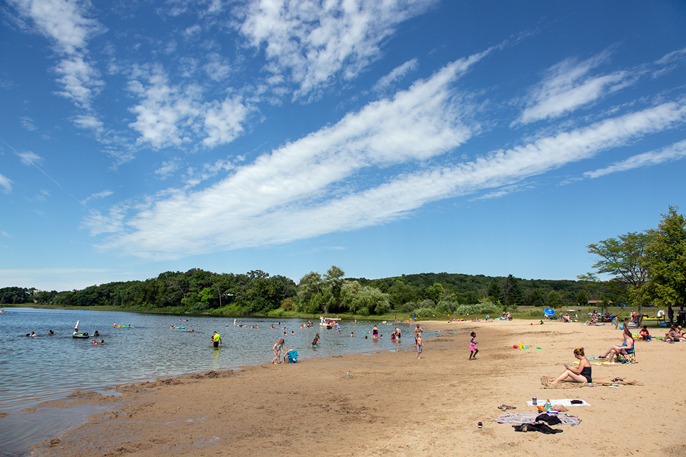 Ottawa Lake beach with bathers and a dramatic sky