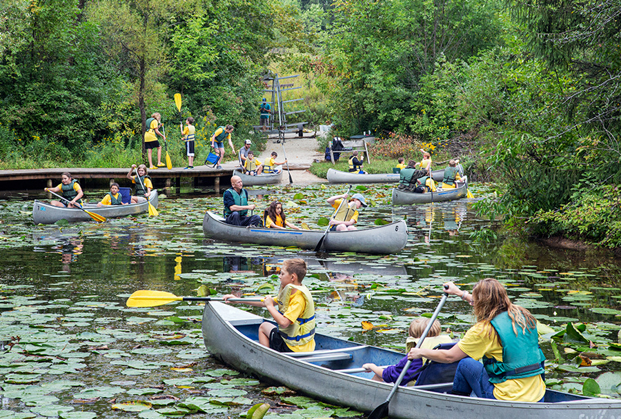 six canoes launching from a boardwalk