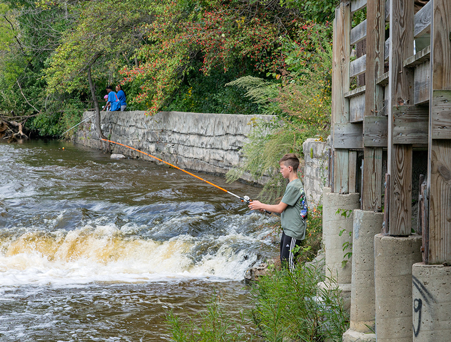 boy fishing from the shore in Estabrook Park