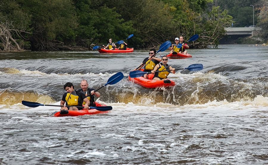 four rafts going over falls on the Milwaukee River