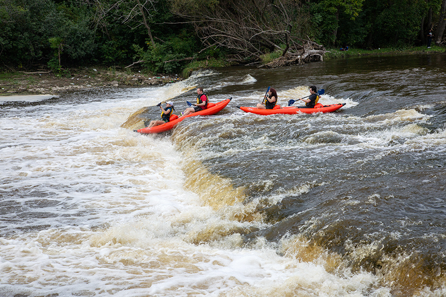 Two rafts going over falls on the Milwaukee River