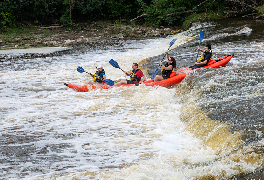 Two rafts going over falls on the Milwaukee River