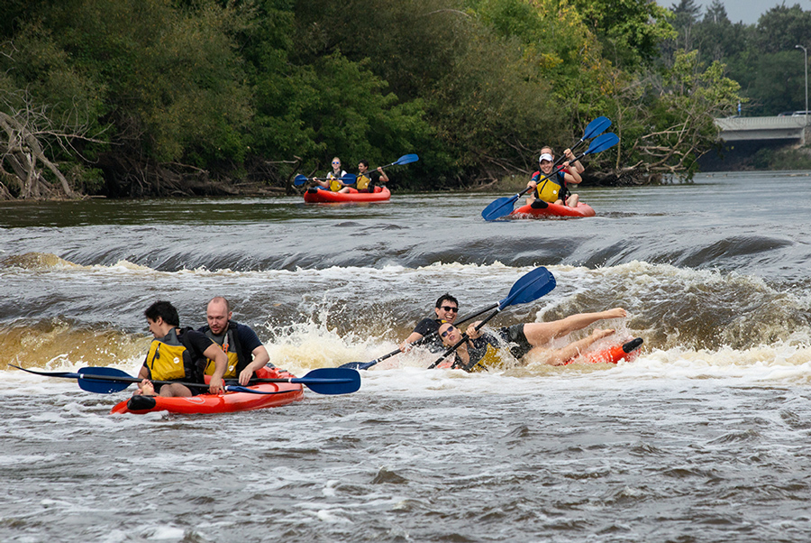 one of four rafts spills as it goes over the falls at Estabrook Park