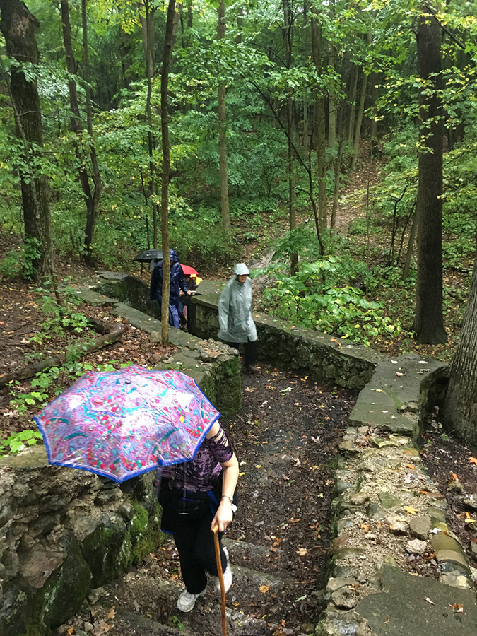 hikers walking up a staircase ruin in Sanctuary Woods