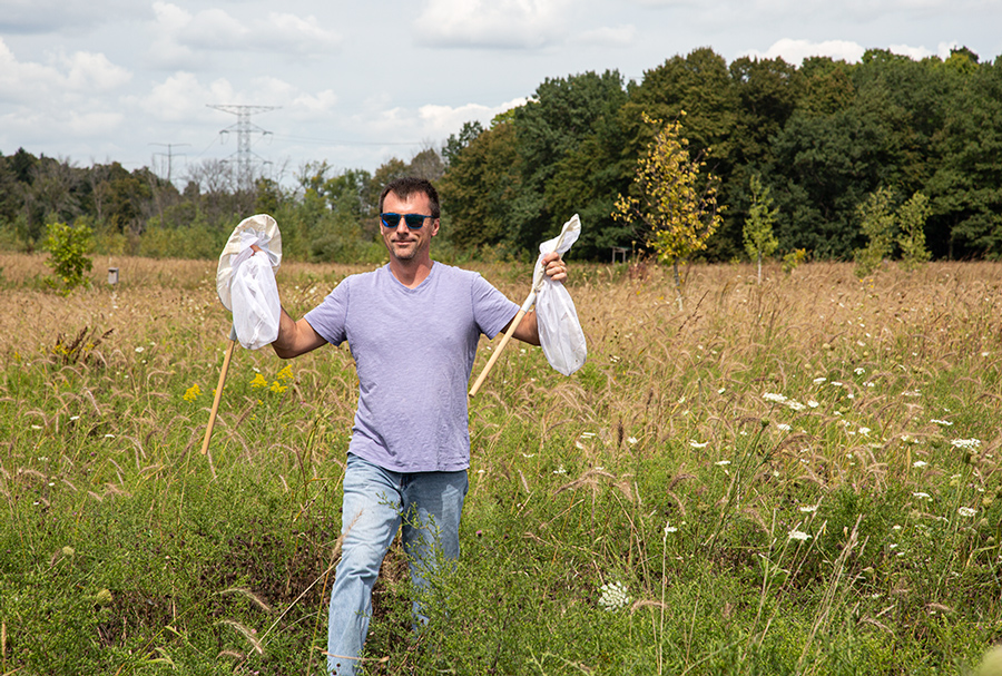 a man holding up two nets that contain monarch butterflies