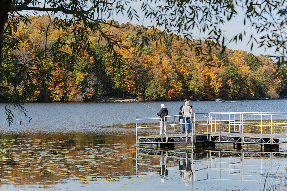 people fishing from a pier on a lake at Ackerman's Grove County Park