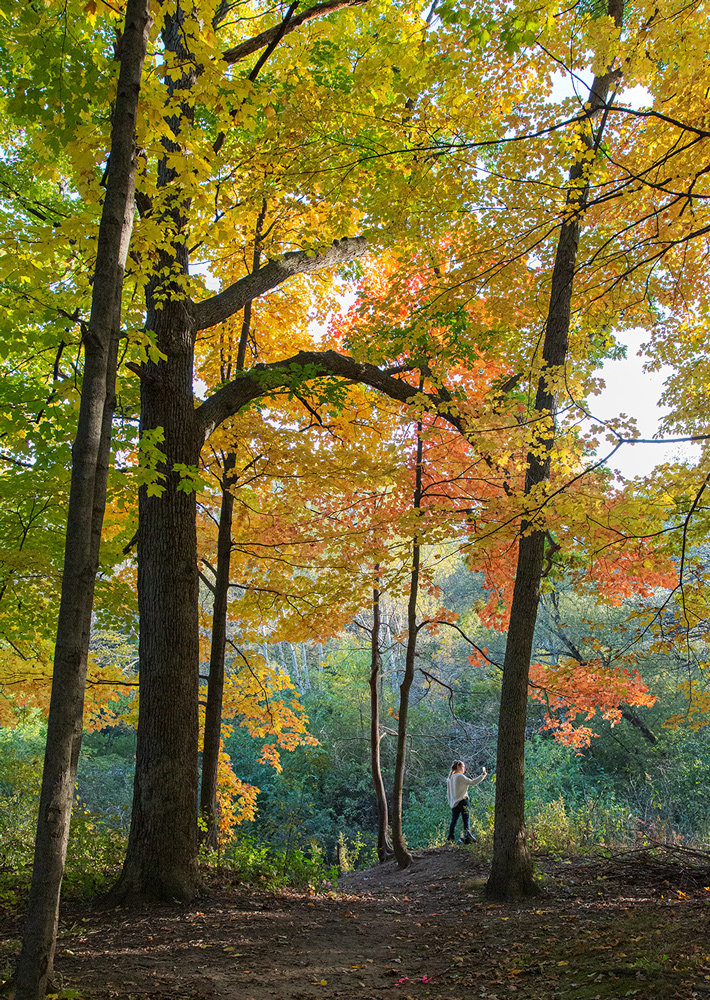 girl taking a selfie in Honey Creek Parkway with autumn colors