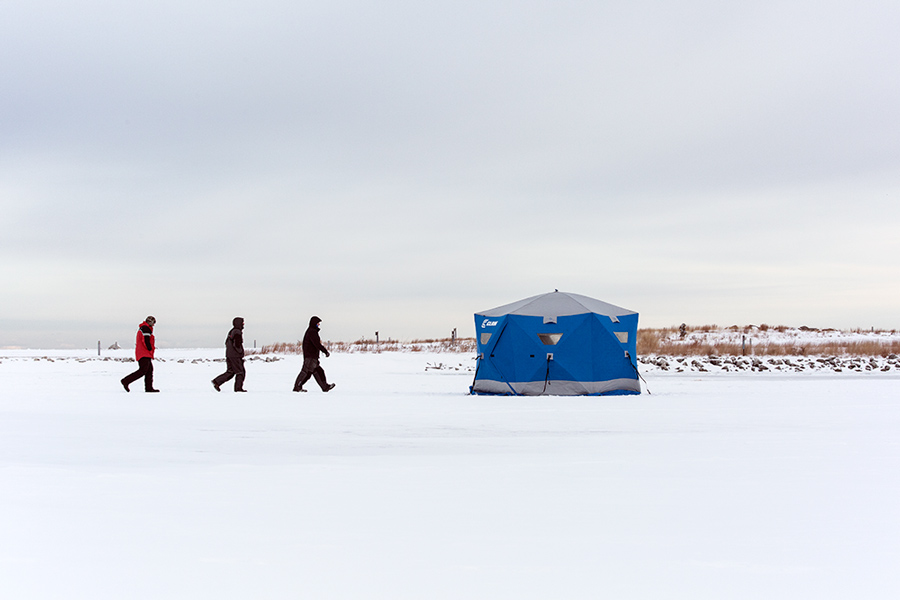 Three ice fishermen and ice fishing hut at Lakeshore State Park.