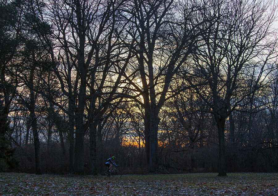 a lone cyclist riding along the Oak Leaf Trail at sunset