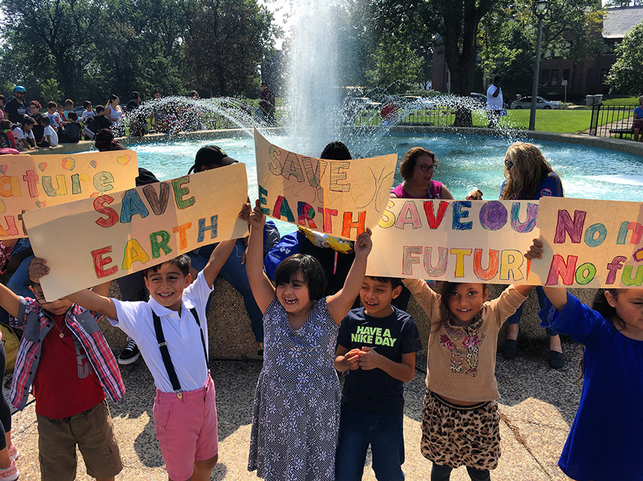 Schoolchildren holding up "Save Earth" signs at Climate Strike rally