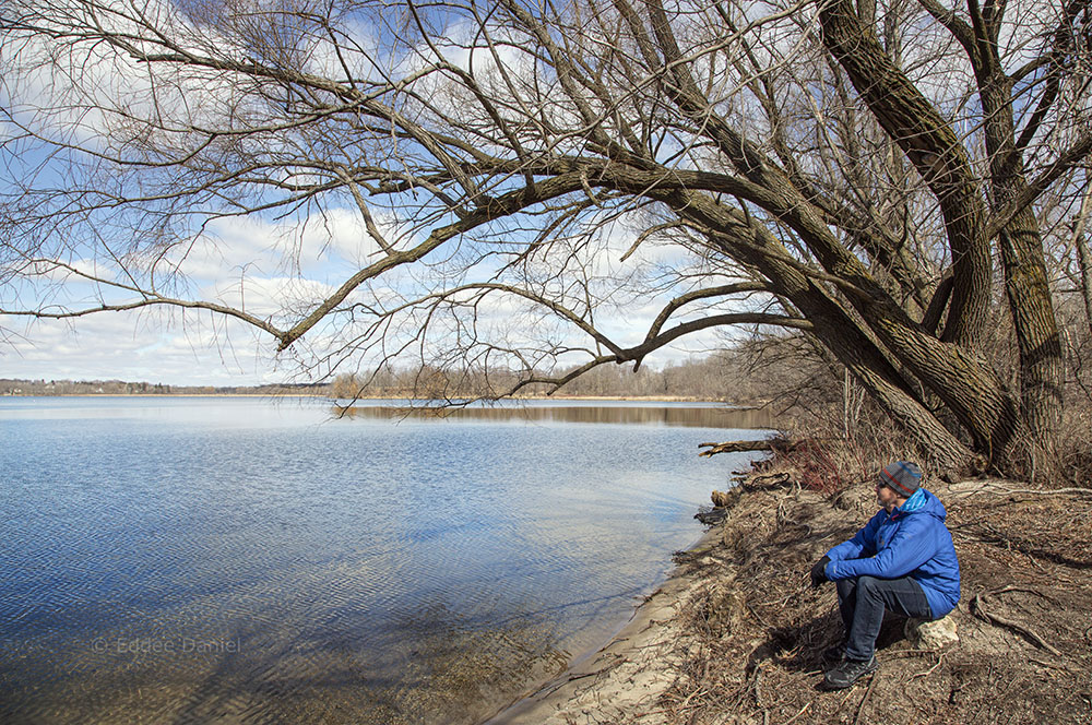 A man sitting next to the lake at Pike Lake Unit - Kettle Moraine State Forest