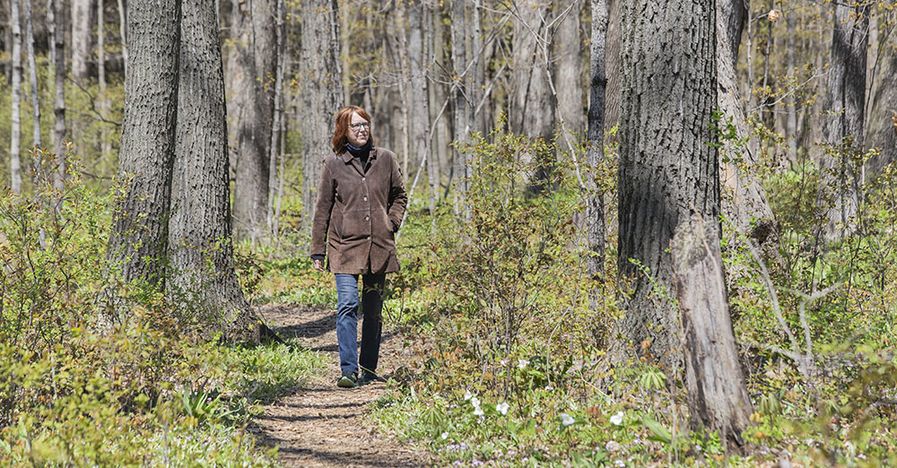 A woman walking on a woodland path in Bratt Woods