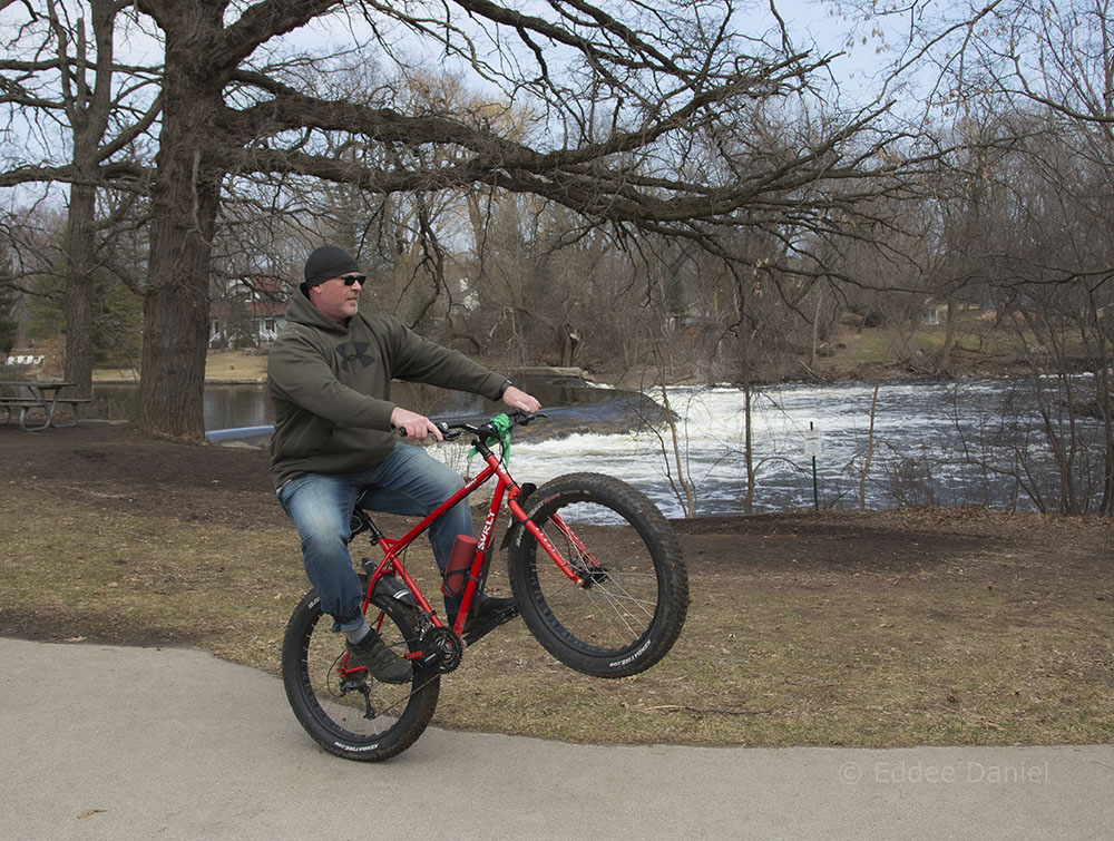 A man doing a wheelie on a fat tire bike in Kletzsch Park