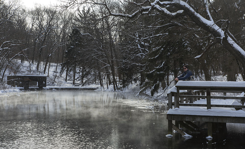 A man fishing in the pond in winter at Paradise Springs Nature Trail