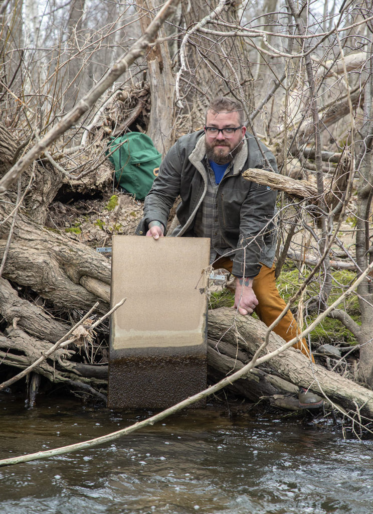 The artist removing a canvas from Sauk Creek.