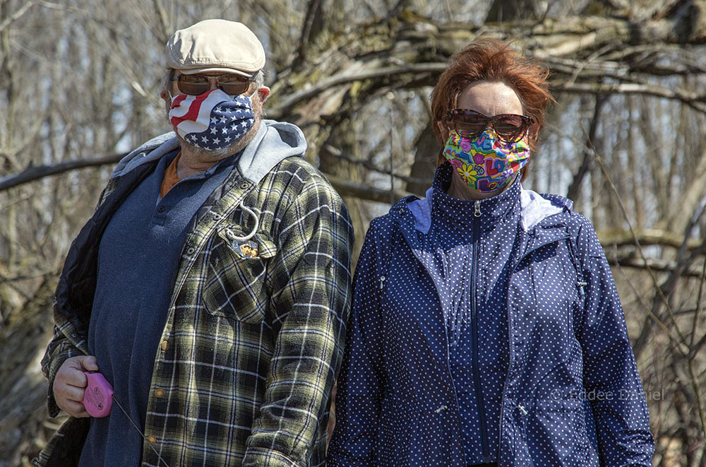 a couple wearing face masks displaying the American flag and "love"