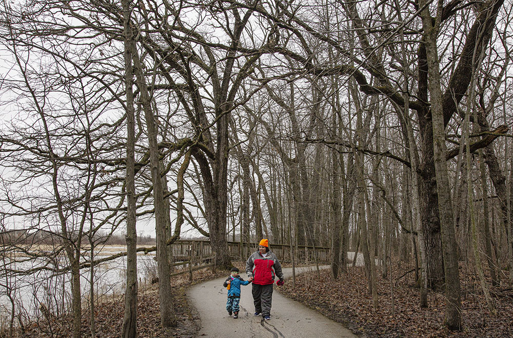 A mother with her young son on the paved riverside path at Fox River Park in Waukesha