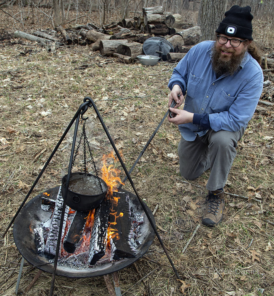 Howard as Andrew Pettigrew with sap boiling over a campfire.