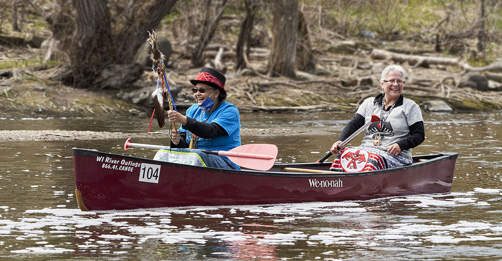 Native Americans in canoe on Milwaukee River