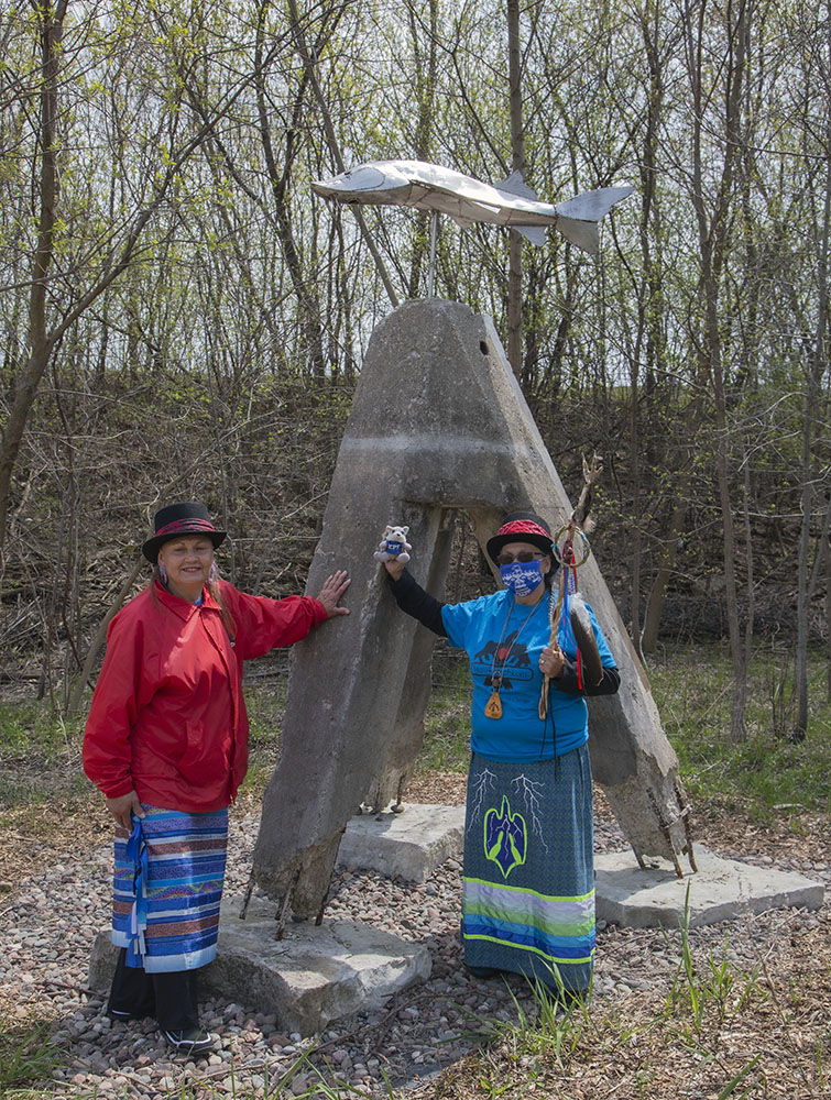 Oralann and Jwin pose at the sturgeon sculpture by Tom Queoff.