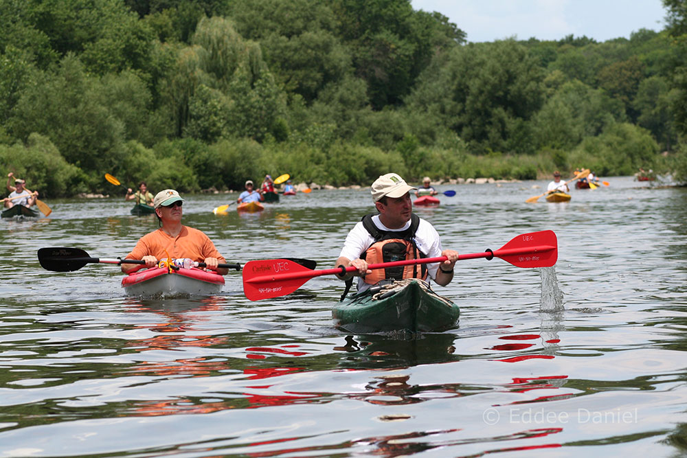 A group of boaters float along the Milwaukee Urban Water Trail (the river) in the Greenway near Riverside Park.