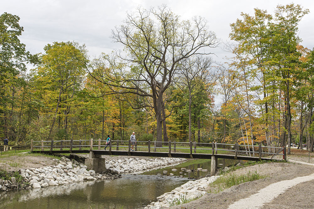 An existing pedestrian bridge is stabilized with newly installed rip rap.