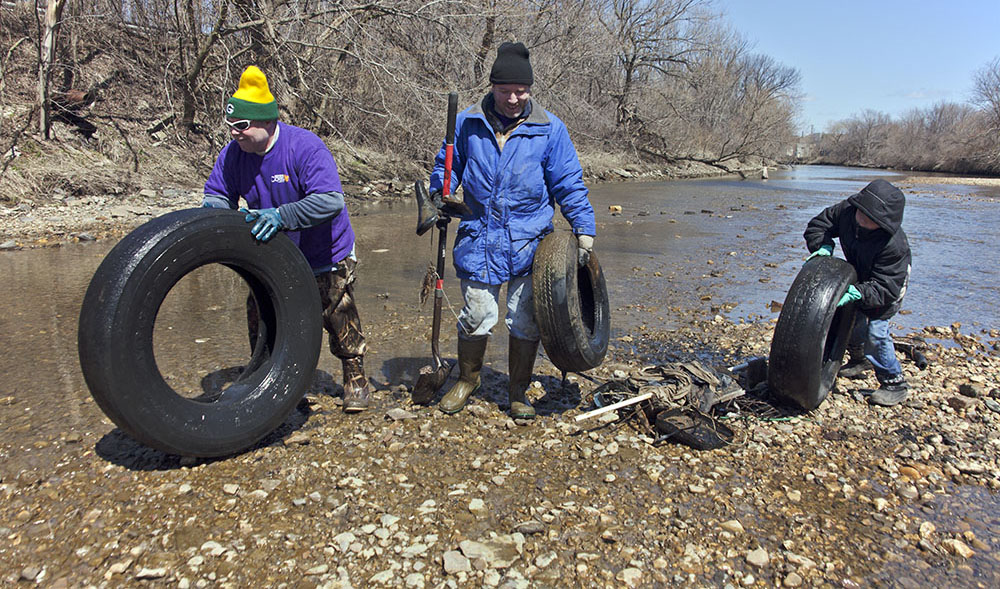 Three large tires being removed from the KK River during 2013 cleanup