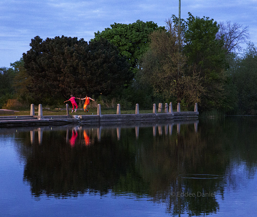 dancers at the edge of the lagoon in front of the Urban Ecology Center