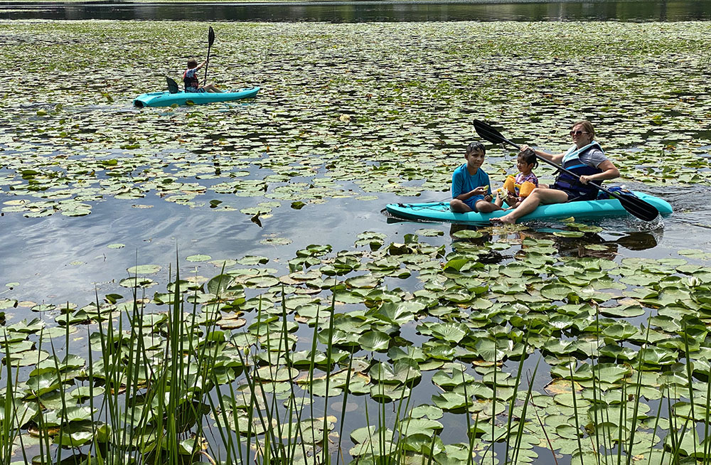 Family kayaking on Little Cedar Lake, Ackerman's Grove County Park