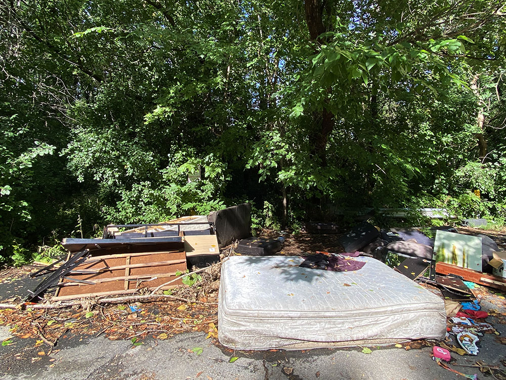 Furniture and other detritus dumped in a cul-de-sac at the entrance to the unnamed woodland.