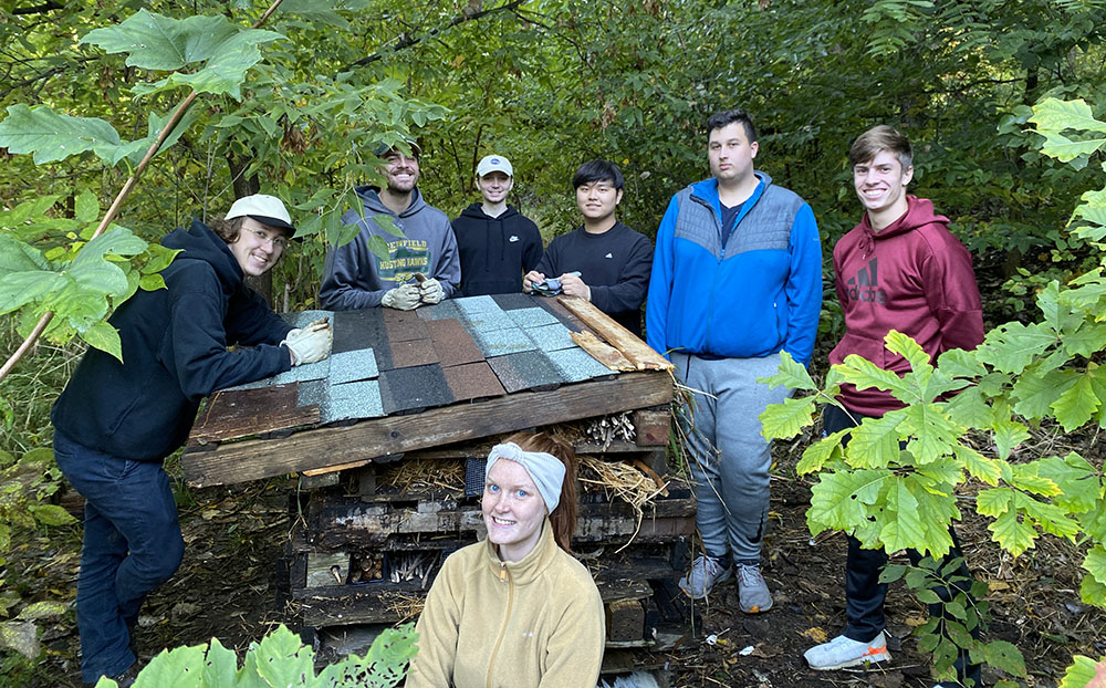 UW-Milwaukee students pose next to a half-finished bug hotel. CP