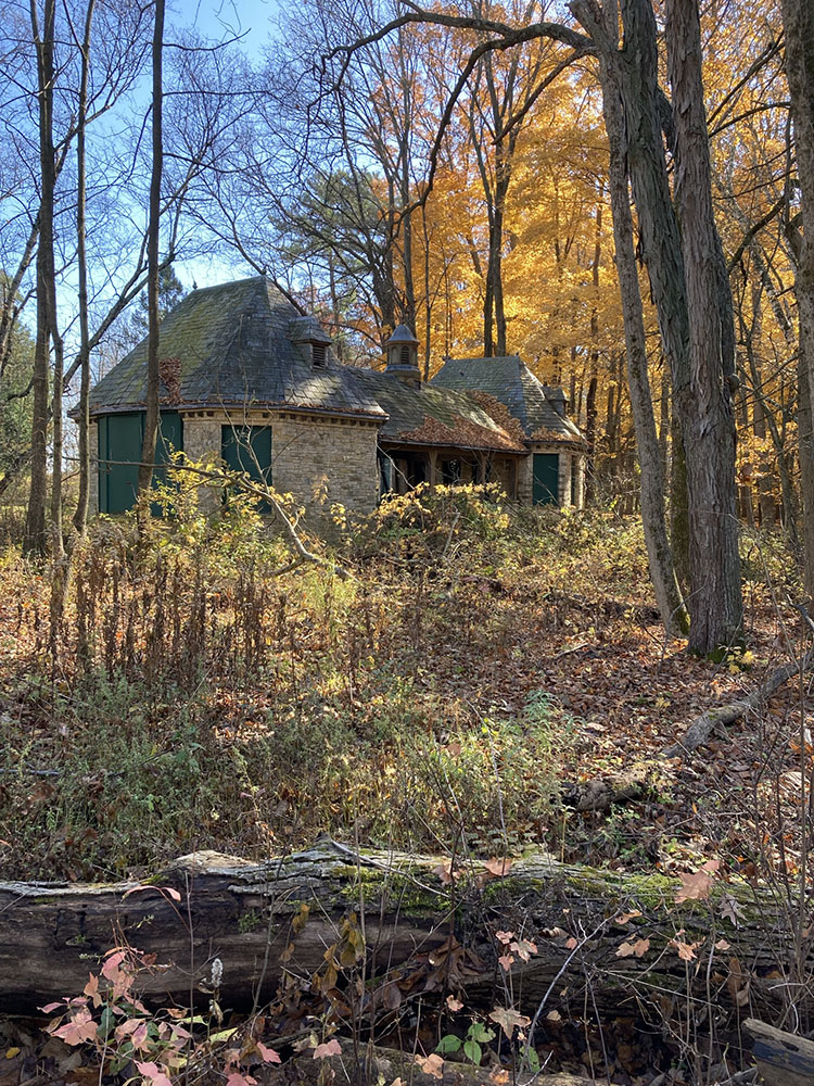 The former bathhouse appears through the trees.