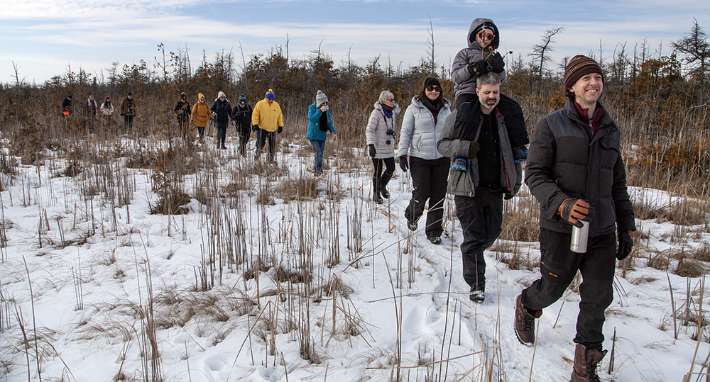 A group hiking in the Cedarburg Bog in winter