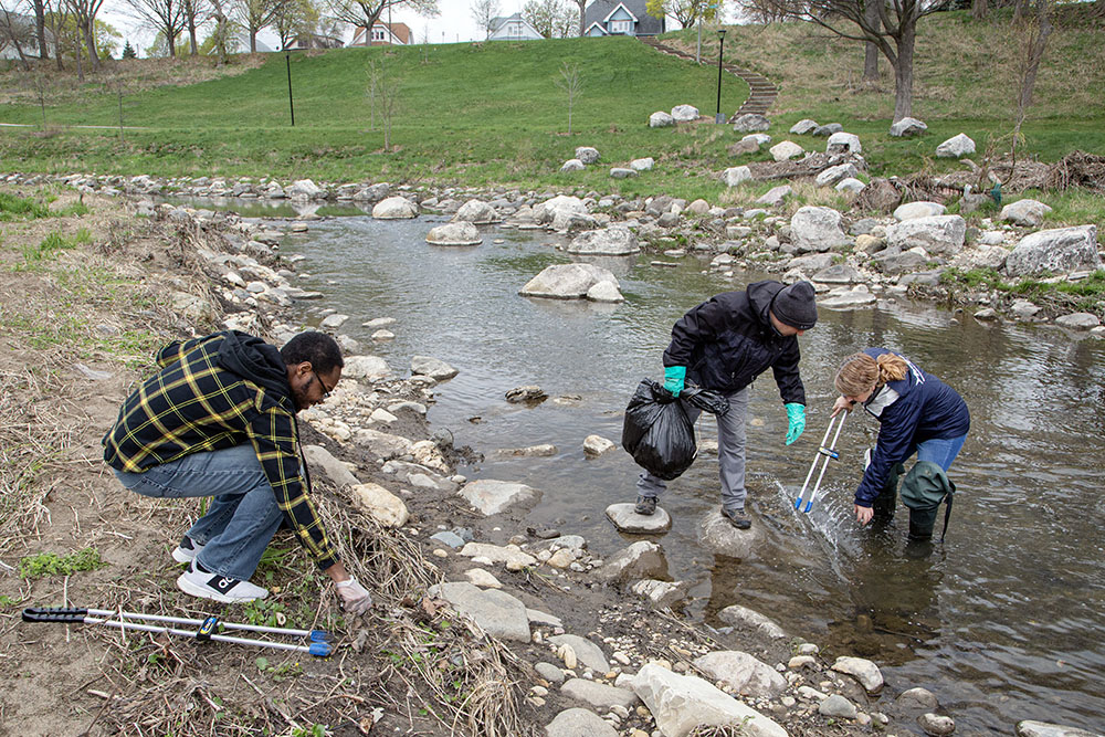 Milwaukee Riverkeeper Cheryl Nenn (far right) and two volunteers cleaning up the KK River in Pulaski Park.