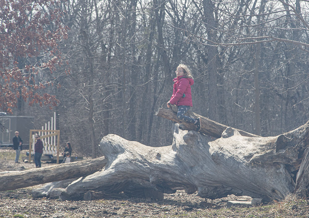 A girl watches the burn atop a perch in the playground.