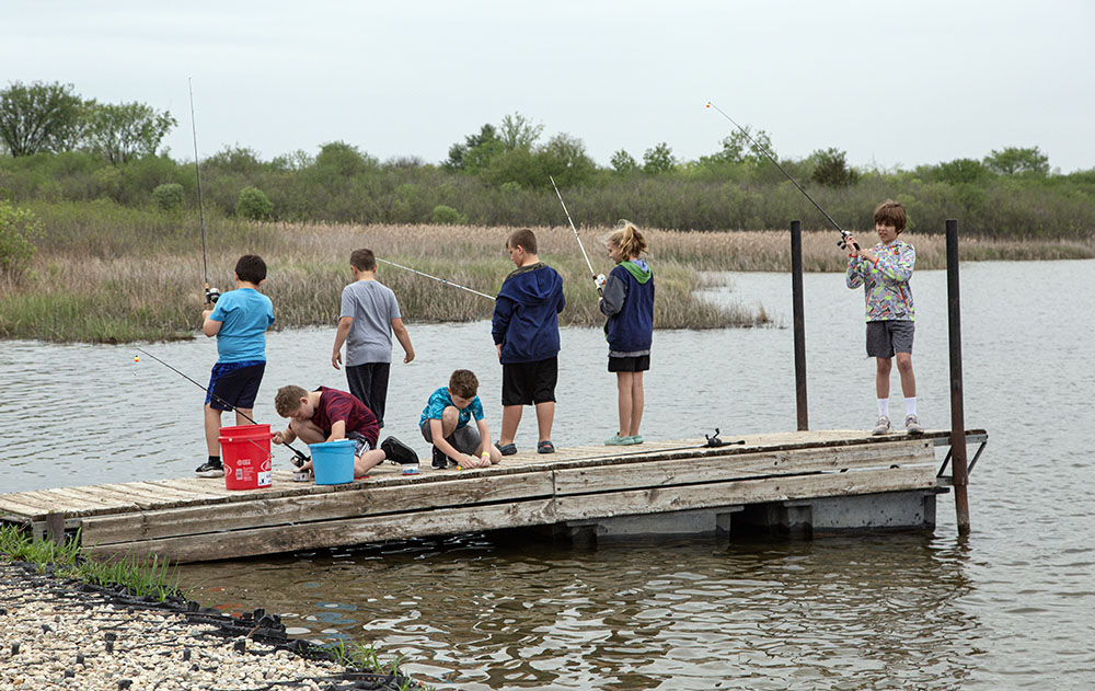 Children fishing from a small pier.